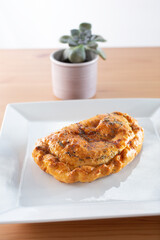 A view of a savory pastry or stuffed pocket appetizer.