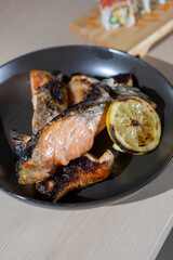 A view of a plate of grilled salmon collar.