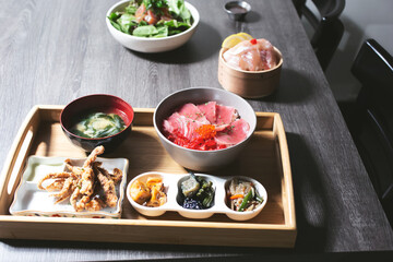 A view of a Japanese restaurant seafood platter, featuring nigiri rice bowl, seaweed salad, deep fried appetizers.