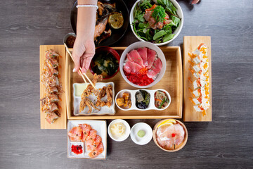A top down view of a Japanese restaurant seafood platter, featuring sushi, rolls, nigiri, and deep fried appetizers.