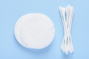White new clean cotton pads and swabs buds on blue background top view flay lay
