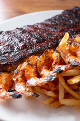 A view of a plate of baby back ribs and grilled shrimp.