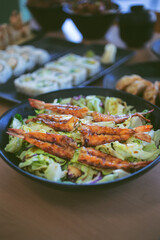 A view of a teriyaki shrimp salad bowl, among other Japanese appetizers.