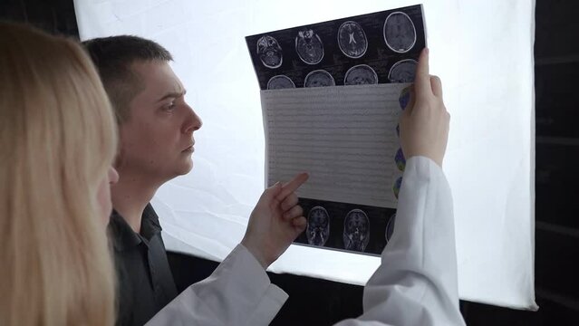 Epileptologist examines patient MRI and electroencephalogram. Concept treating epilepsy and helping people who suffer from this disease. Neurologist at work. Pathology of the brain. Seizure activity