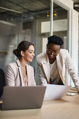 Happy black businesswoman and her colleague work on new ideas in office.