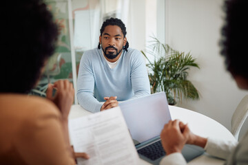 African American job candidate talks to members of human resource team during meeting in office.