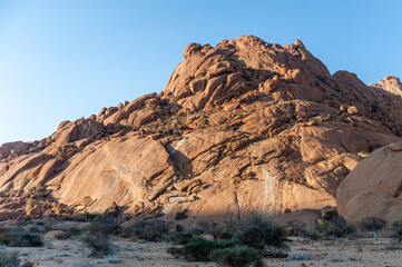 Bold rock formations glowing bright orange in the last rays of the setting sun. Spitzkoppe, Namibia.