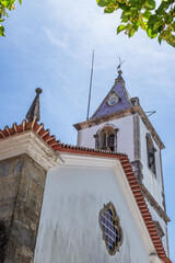Perspective of tiles and facade with rose window and bell tower of the parish church of Luso,...