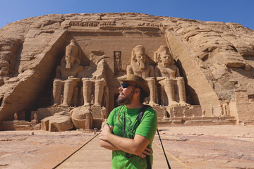 White Man Tourist in front of the Colossal Statues of Ramesses II seated on a throne near the...