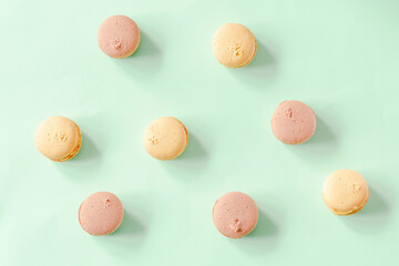 Sweet chocolate,lemon macarons,cookies lying on green background, pastry, confectionery desserts, tasty sugar food.copy space