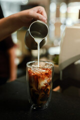 Barista pouring coffee in glass
