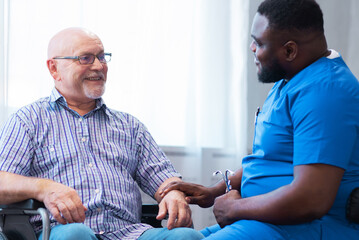 Professional doctor helps an elderly man with chronic diseases. Therapist and patient in home...