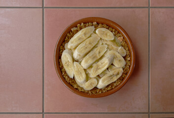 Sliced bananas have been added to a biscuit base in the making of a banoffee pie