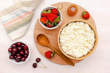 Cottage cheese with summer strawberries cherry berries.curd cheese in bowl with honey.Healthy dairy Calcium,Protein product,food breakfast,lunch,lifestyle,dieting, detox,proper nutrition.Top view