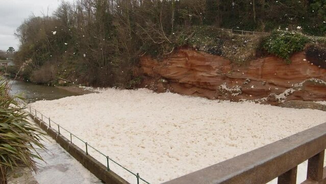 Sea foam cappuccino coloured swirls in wind coast Sidmouth south west England