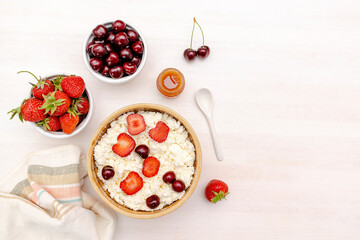 Obraz na płótnie Canvas Cottage cheese with summer strawberries cherry berries.curd cheese in bowl with honey.Healthy dairy Calcium,Protein product,food breakfast,lunch,lifestyle,dieting, detox,proper nutrition.Top view