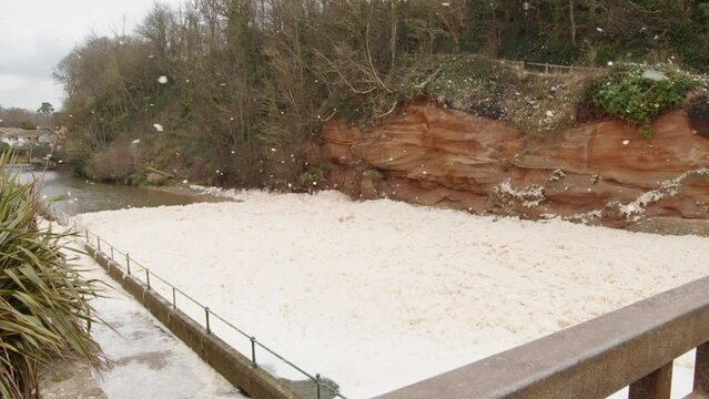 Sea foam cappuccino coloured swirls in wind coast Sidmouth south west England