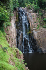 Fototapeta na wymiar Waterfall called Haew Narok covered by green trees inside tropical rainforest.