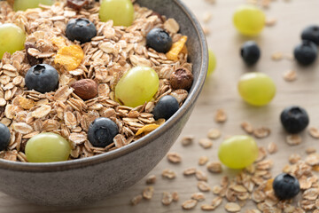 Frühstücksmüsli in einer Schale mit frischen Weintrauben und Heidelbeeren 