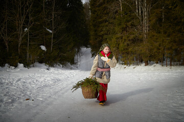 Nice cute teenager girl in old peasant clothes with hot fur coat and shawl in cold winter forest...
