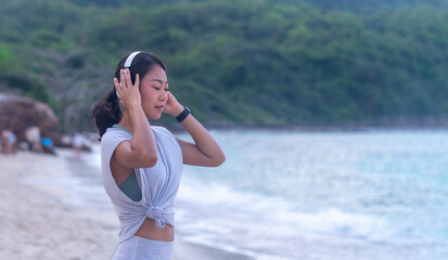 Portrait Asian joyful tanned woman relaxing with favorite music at beach show smiling happiness...