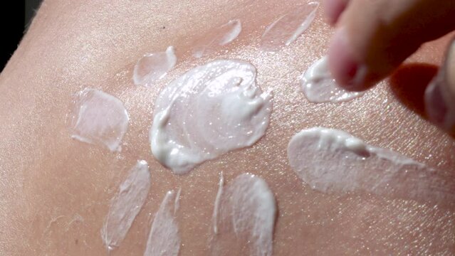 woman,girl, is drawing with hand with body lotion,spf protection cream.sun shape on shoulder,sea beach vacation concept,skin body care,usa rays protection.close up 4k video real time.
