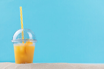 glass of orange juice on the beach