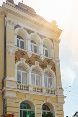 Obraz premium architecture of nineteenth century, an old yellow house with stucco and monograms, in rays of sun. Austria, Baden 