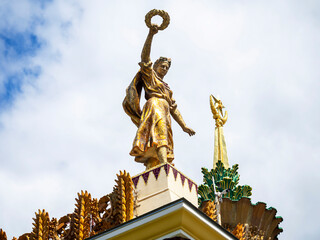 Fototapeta premium The golden figure of a man holds a wreath over the world.