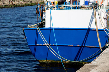 Fototapeta na wymiar Stern of Blue Painted Fishing Boat at a Harbour Location