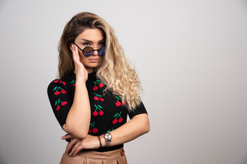 Fototapeta premium Long haired blonde woman in sun glasses looking at somewhere