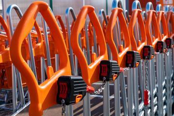 Shopping trolleys with orange handles lined up at hardware store.