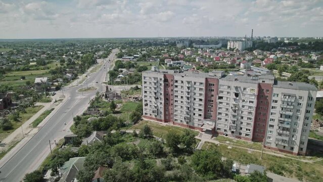 Drone flight over a destroyed residential building and adjacent broken private houses