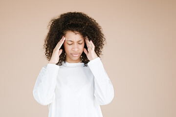 Young african american woman over isolated background suffering from headache desperate and stressed because pain and migraine. Hands on head                           