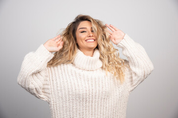 Blonde woman in winter outfit playing with her hair