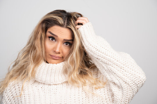 Blonde Woman In Winter Outfit Scratching Her Hair