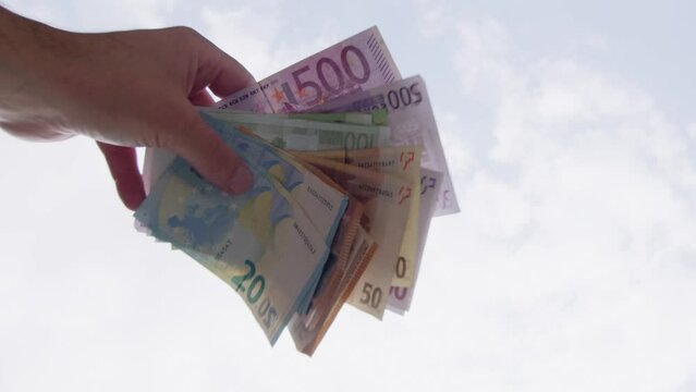 hand letting Euro banknotes fall in slow motion