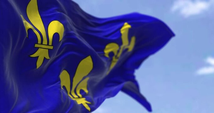 The flag of Ile de France region waving in the wind on a clear day