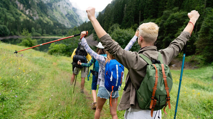 Group of young friends hiking in countryside. Multiracial happy people travelling