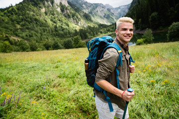 Adventure man hiking wilderness mountain with backpack