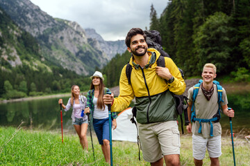 Group of happy fit friends hiking, trekking together outdoor nature