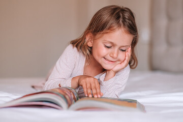 Close up focused child girl read book in bed. International literacy day