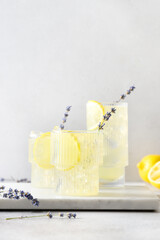 Sparkling summer lavender lemonade in glasses on gray background. Vertical format. Close up. Summer...