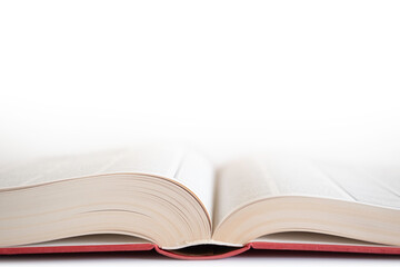 Open book with red cover on white background. Narrow depth of field