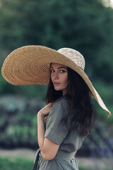 Portrait of woman in wide-brimmed hat on meadow.