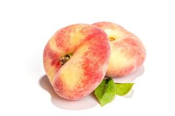 Ripe organic chinese flat fig peach, whole and slices, with leaves isolated on white background