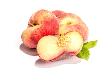 Ripe organic chinese flat fig peach, whole and slices, with leaves isolated on white background