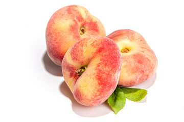 Ripe organic chinese flat fig peach, whole and slices, with leaves isolated on white background