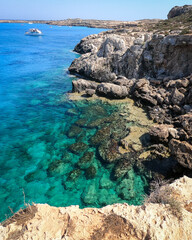 View of the sea and cliffs of Blue Lagoon, Cape Greco, Cyprus. Small boats anchored at the bay. 