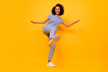 Full body portrait of excited crazy girl raise leg footwear sole dancing isolated on yellow color...